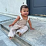 toddler, child, smiling, sitting, outdoor, concrete, step, door, hair_accessory, pony_tail, beige_clothing, sandals, cute, happy, person, sidewalk, curb, wall, exploring, young_child