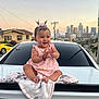Alison is registered to the contest to win money with this photo: baby, child, smiling, clapping, pink_dress, bow, blanket, car, dodge, urban, city_skyline, sunset, happy, outdoor, pigtails, infant, cute, vehicle, street, portrait