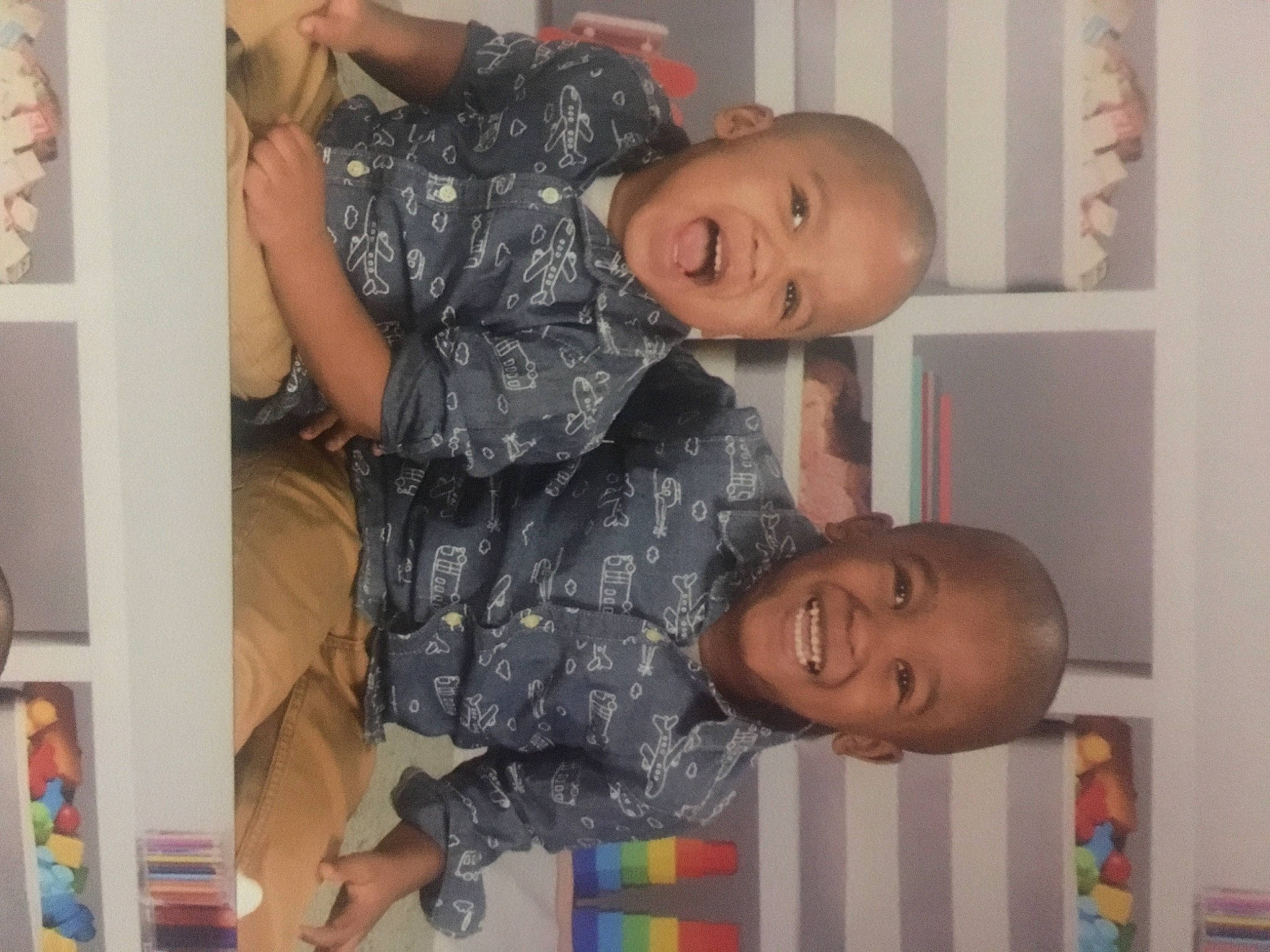 Kyair is registered to the contest to win money with this photo: arm, baby, baby_toddler_clothing, child, face, fun, gesture, happy, head, joy, pattern, person, play, room, smile, t_shirt, thigh, thumb, toddler