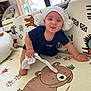 Léo a rejoint le concours — aidez-le/la à gagner de superbes lots ! baby, child, crawling, play_mat, cartoon_bear, sock, white_cloth, indoors, curious, cute, playful, smiling, headwear, floor_mat, colorful, furniture, window, daylight, person, home