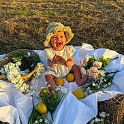 Sophia joined the competition — help win amazing prizes! baby, child, hat, smiling, grass, lemons, flowers, basket, white_cloth, field, outdoor, sunlight, nature, happy, sitting, cute, summer, playful, portrait, toy
