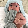 Noah is registered to the contest to win money with this photo: baby, infant, towel, hooded_towel, blanket, diaper, chewing, face, skin, arm, hand, expression, wide_eyes, curious, indoors, soft_texture, cute, portrait, newborn, lying_down