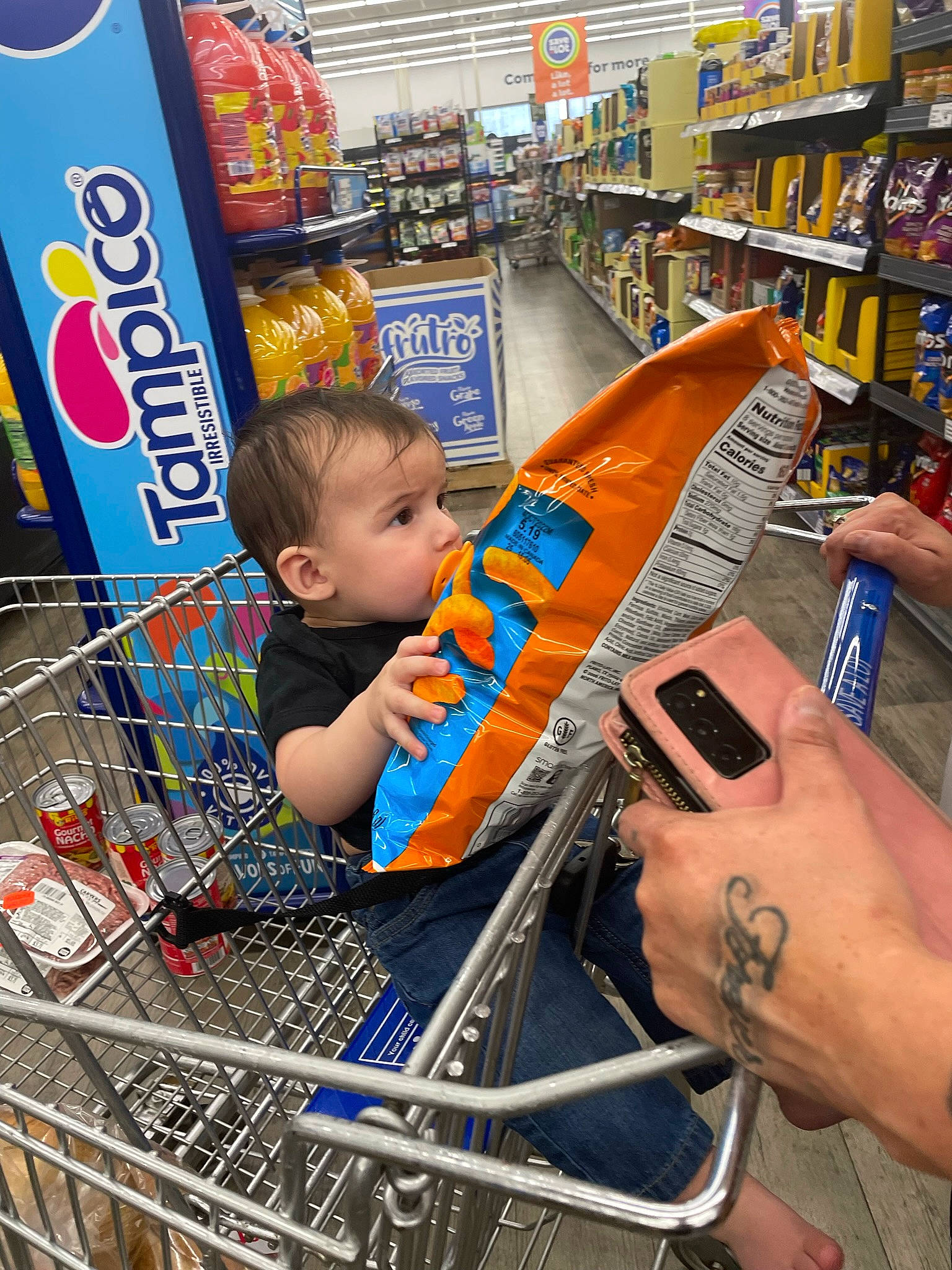 Landon is registered to the contest to win money with this photo: cart, convenience_store, customer, engineering, fun, grocery_store, hand, human_leg, leisure, person, photograph, product, publication, retail, shelf, shopping, shopping_cart, snapshot, tire, toddler
