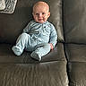 baby, infant, onesie, couch, leather, smile, face, child, indoor, blanket, seated, cute, cozy, home, portrait, young_child, comfortable, happy, skin, furniture