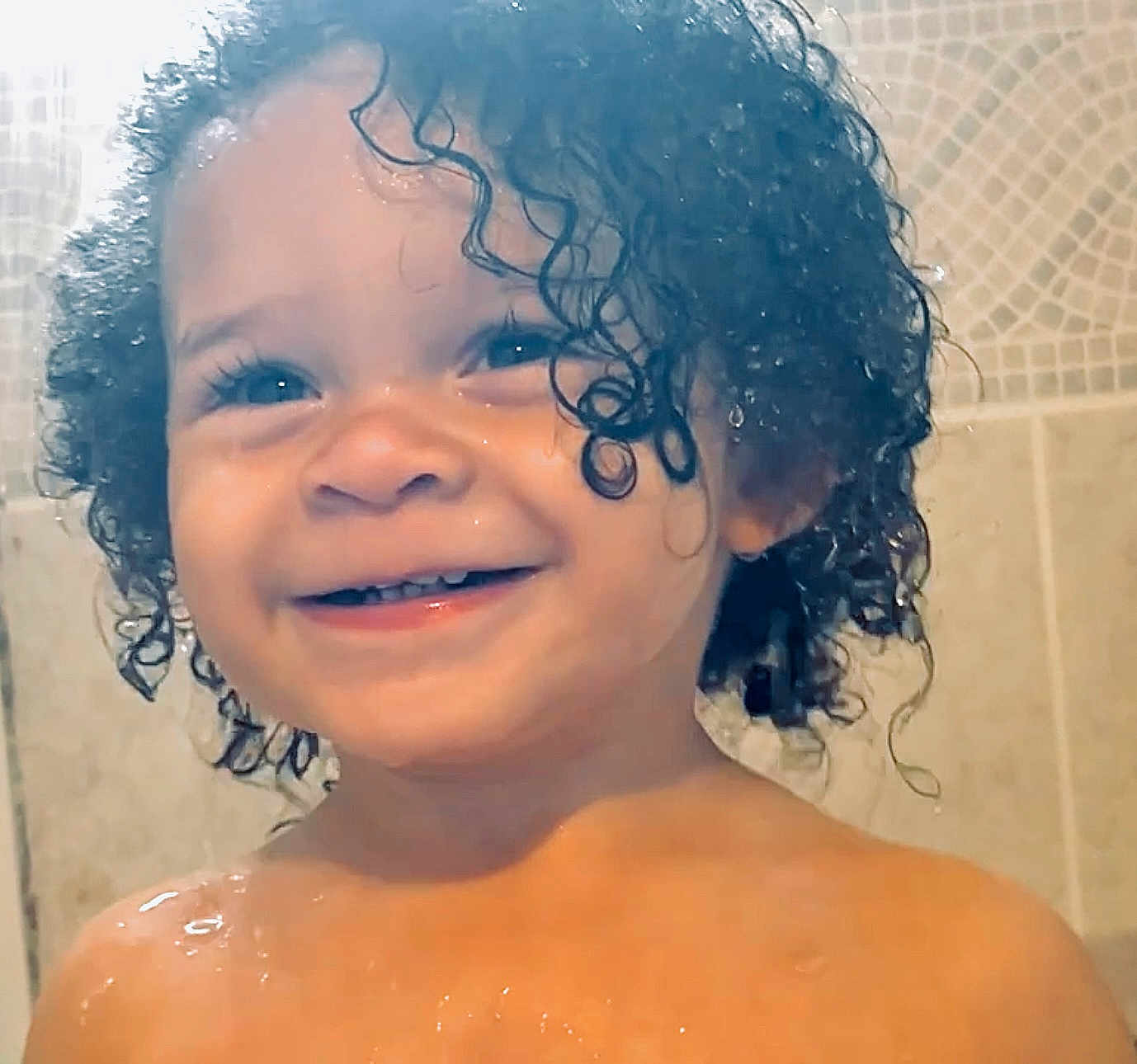 Jakarii joined the competition — help win amazing prizes! toddler, child, smiling, curly_hair, wet_hair, water_droplets, bathroom, tile_wall, portrait, close_up, happy, skin, face, head, young_child, person, cute, indoors, shower, expression