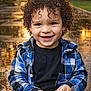 autumn_leaves, blue_shirt, child, curly_hair, cute, daylight, fall, happy, nature, outdoor, person, plaid_shirt, playing, portrait, rain, seasonal, smiling, sunset, toddler, wet_path