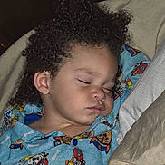 Jakarii joined the competition — help win amazing prizes! child, sleeping, curly_hair, pajamas, blue_pajamas, cartoon_print, bed, pillow, blanket, indoors, peaceful, closeup, face, young_child, resting, cozy, cute, person, nap, comfort