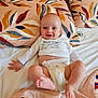 Kaïs a rejoint le concours — aidez-le/la à gagner de superbes lots ! baby, infant, smiling, diaper, bed, pillow, blanket, leaf_pattern, pacifier, child, happy, cute, lying_down, indoors, white_clothing, foot, hand, face, head, cozy
