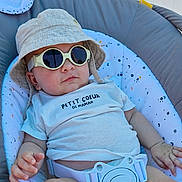 Kaïs participe au concours pour gagner de l'argent avec cette photo : baby, child, sunglasses, hat, bucket_hat, clothing, seat, cushion, safety_belt, infant, cute, relaxed, indoor, person, fashion, casual, portrait, smile, hand, foot