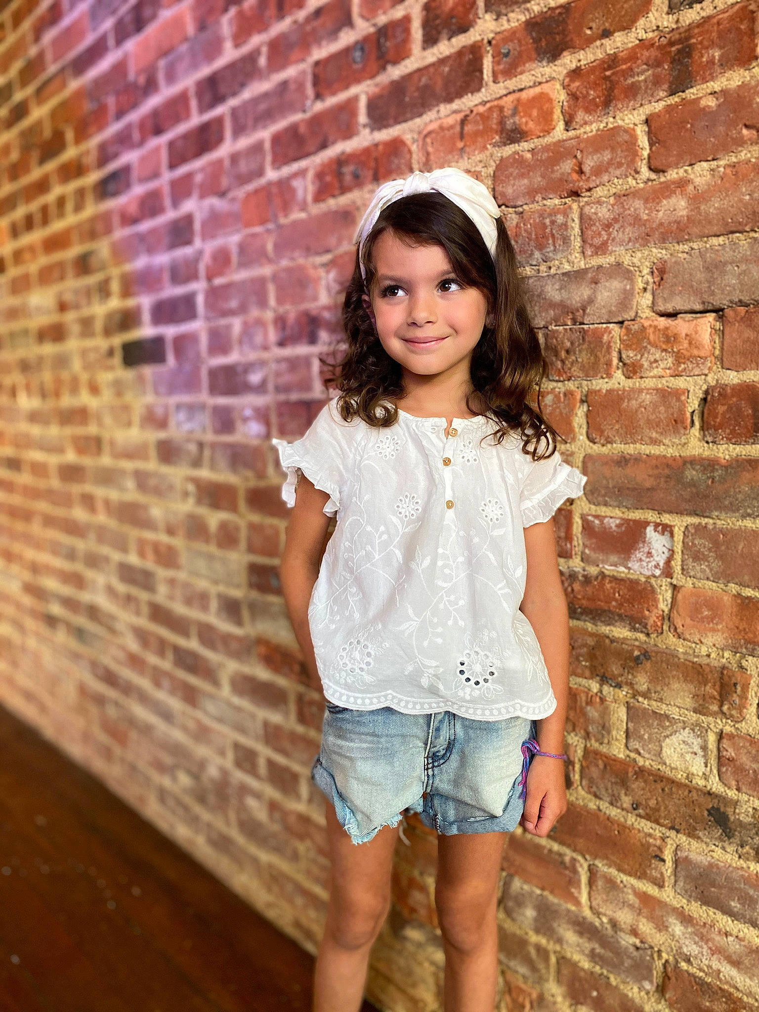 Sadie Snow is registered to the contest to win money with this photo: brick, brickwork, chin, clothing, face, flash_photography, hair, happy, head, jean_short, joy, lip, neck, person, pink, shorts, shoulder, skin, sleeve, smile