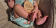 Sophira joined the competition — help win amazing prizes! baby, infant, smiling, onesie, flower_pattern, baby_seat, cushion, wooden_sign, three_months, happy, face, feet, hand, skin, cute, child, indoors, soft_fabric, portrait, person