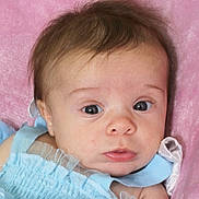 Sophira is registered to the contest to win money with this photo: baby, infant, face, blue_dress, pink_blanket, close_up, portrait, child, young, cute, soft_texture, looking, eyes, skin, hair, expression, newborn, toddler, apparel, resting