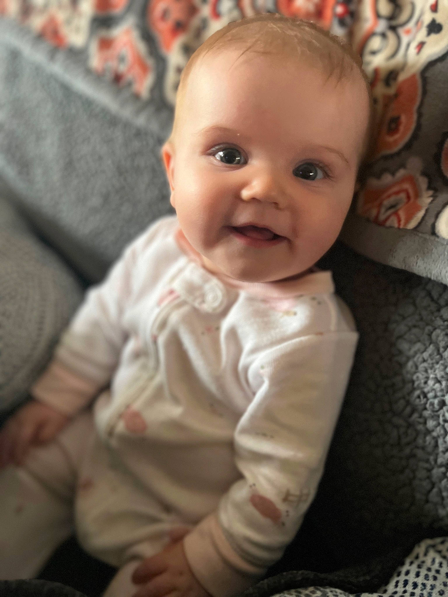 Neriah is registered to the contest to win money with this photo: baby, baby_toddler_clothing, cheek, child, comfort, eye, flash_photography, flooring, happy, head, iris, linens, lip, nose, person, room, sitting, skin, sleeve, smile