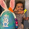 Soraya joined the competition — help win amazing prizes! toddler, child, toy, easter_egg, bunny_ears, carrot, pajamas, chair, indoor, smiling, happy, cute, decorations, colorful, plush, holiday, celebration, baby, person, playful