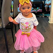 Soraya joined the competition — help win amazing prizes! birthday, boy, celebration, child, couch, curly_hair, decor, family, flooring, gold_bow, headband, home, indoor, person, pink_tutu, playpen, shoes, smiling, toddler, white_shirt