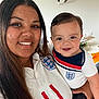 Ronald is registered to the contest to win money with this photo: woman, baby, child, smile, indoor, portrait, person, clothing, football_shirt, happy, family, home, long_hair, short_hair, skin, face, holding, casual, together, people