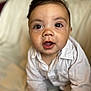 Ronald is registered to the contest to win money with this photo: baby, infant, child, face, eyes, mouth, white_shirt, curious, close_up, portrait, sitting, soft_background, cute, indoors, skin, young, expression, person, head, human