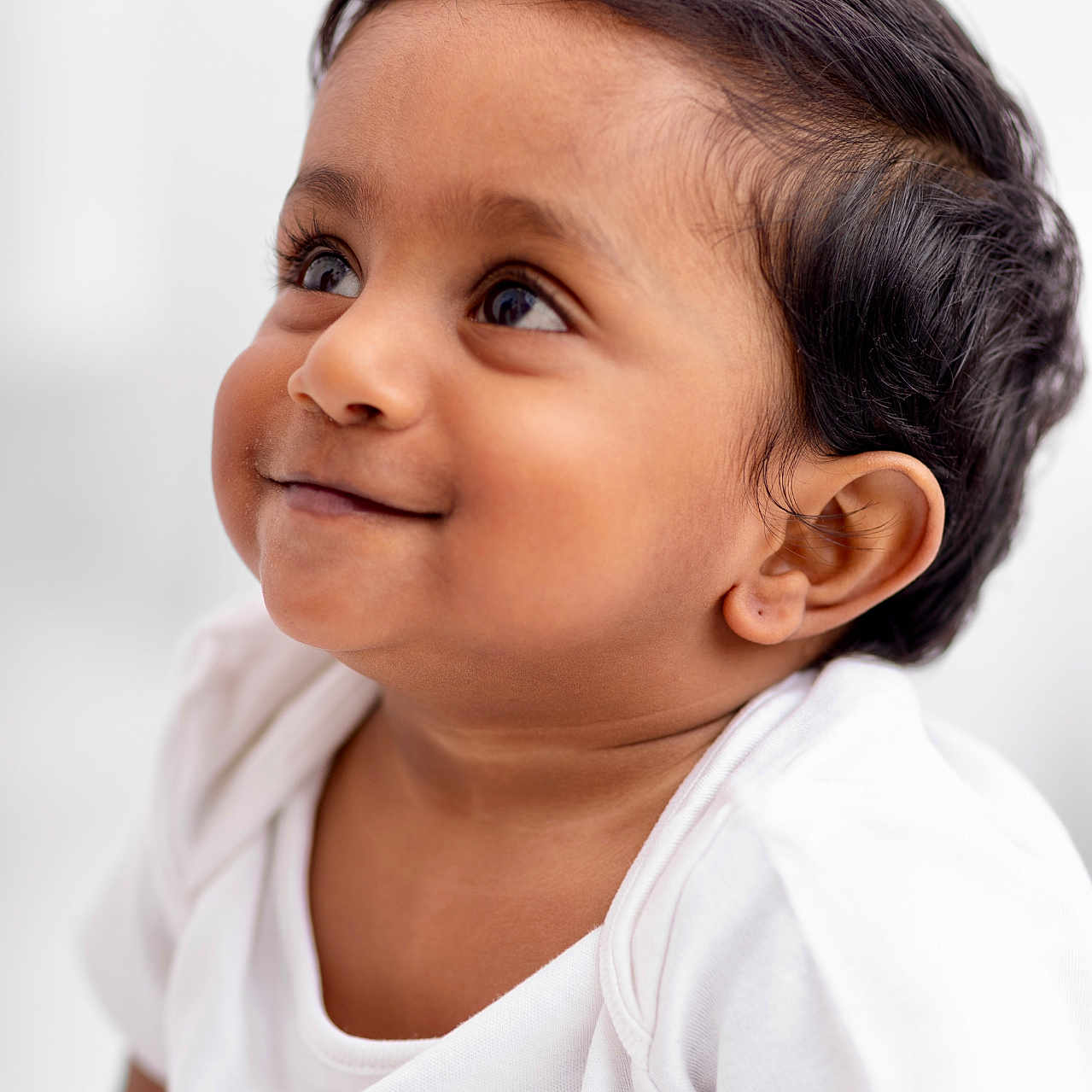 Dev participe au concours pour gagner de l'argent avec cette photo : baby, cheeks, child, close_up, curly_hair, cute, ear, expression, eyelashes, face, happy, head, innocence, looking_up, person, portrait, skin, smile, white_shirt, young