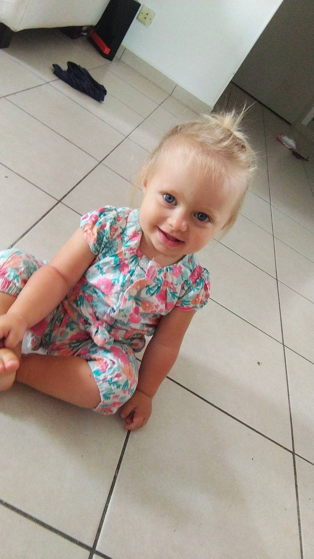 Mïa a rejoint le concours — aidez-le/la à gagner de superbes lots ! baby_toddler_clothing, cheek, face, facial_expression, floor, flooring, fun, happy, hardwood, human_leg, joint, joy, knee, leg, pattern, person, skin, smile, t_shirt, thigh