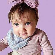 Emma is registered to the contest to win money with this photo: baby, child, blue_eyes, pink_bow, headwear, scarf, long_sleeve, knitwear, portrait, closeup, cute, smiling, indoor, fashion, infant, person, looking_at_camera, soft_background, pastel_colors, adorable
