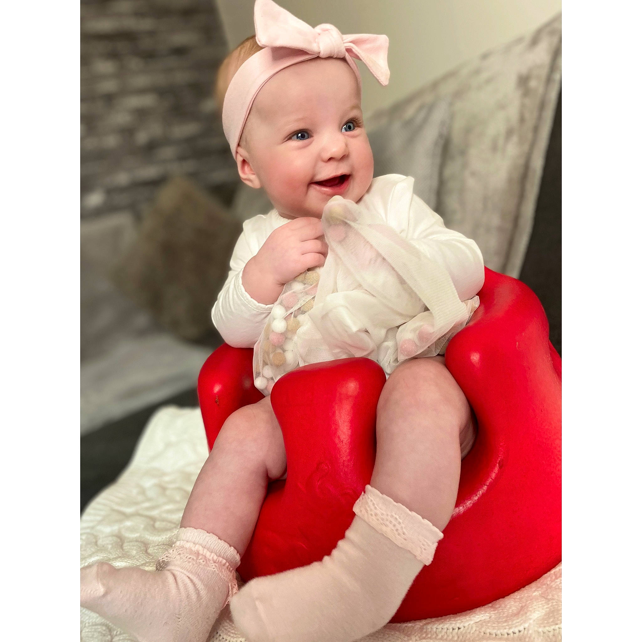 Dolcie is registered to the contest to win money with this photo: arm, baby, baby_products, child, child_model, footwear, headwear, joy, leg, person, play, product, red, shoe, sitting, thigh, toddler, white