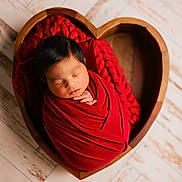 Niall is registered to the contest to win money with this photo: newborn, baby, sleeping, swaddled, red_blanket, heart_shaped_basket, wooden_basket, portrait, infant, peaceful, closed_eyes, hands, face, hair, indoor, wooden_floor, cozy, rustic, photography, red