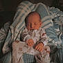 baby, sleeping, blanket, onesie, cozy, infant, child, cute, peaceful, soft, striped_blanket, animal_print, indoors, resting, comfortable, portrait, newborn, warm, hands, face