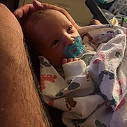 Cody joined the competition — help win amazing prizes! newborn, baby, pacifier, blanket, infant, wrapped, resting, adult_arm, skin, tattoo, cozy, sleepy, cute, footprint_pattern, indoor, soft_lighting, tenderness, closeup, portrait, comfort