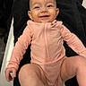 baby, black, child, clothing, cute, expression, face, happy, indoor, infant, lying_down, onesie, peach_color, person, skin, small_hands, small_legs, smiling, texture, towel