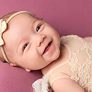 Aubri joined the competition — help win amazing prizes! adorable, baby, bow, child, closeup, clothing, cute, face, happy, headband, infant, lace, lying_down, newborn, person, pink_background, portrait, skin, smile, soft_texture