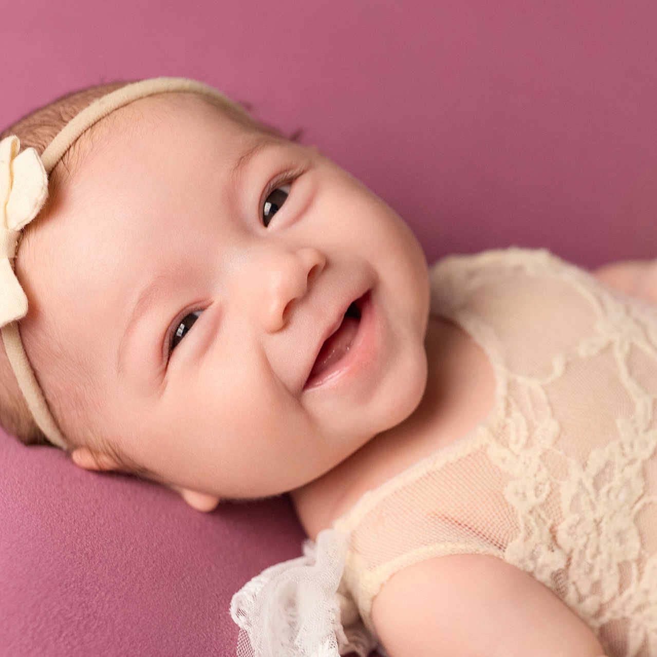 Aubri joined the competition — help win amazing prizes! adorable, baby, bow, child, closeup, clothing, cute, face, happy, headband, infant, lace, lying_down, newborn, person, pink_background, portrait, skin, smile, soft_texture