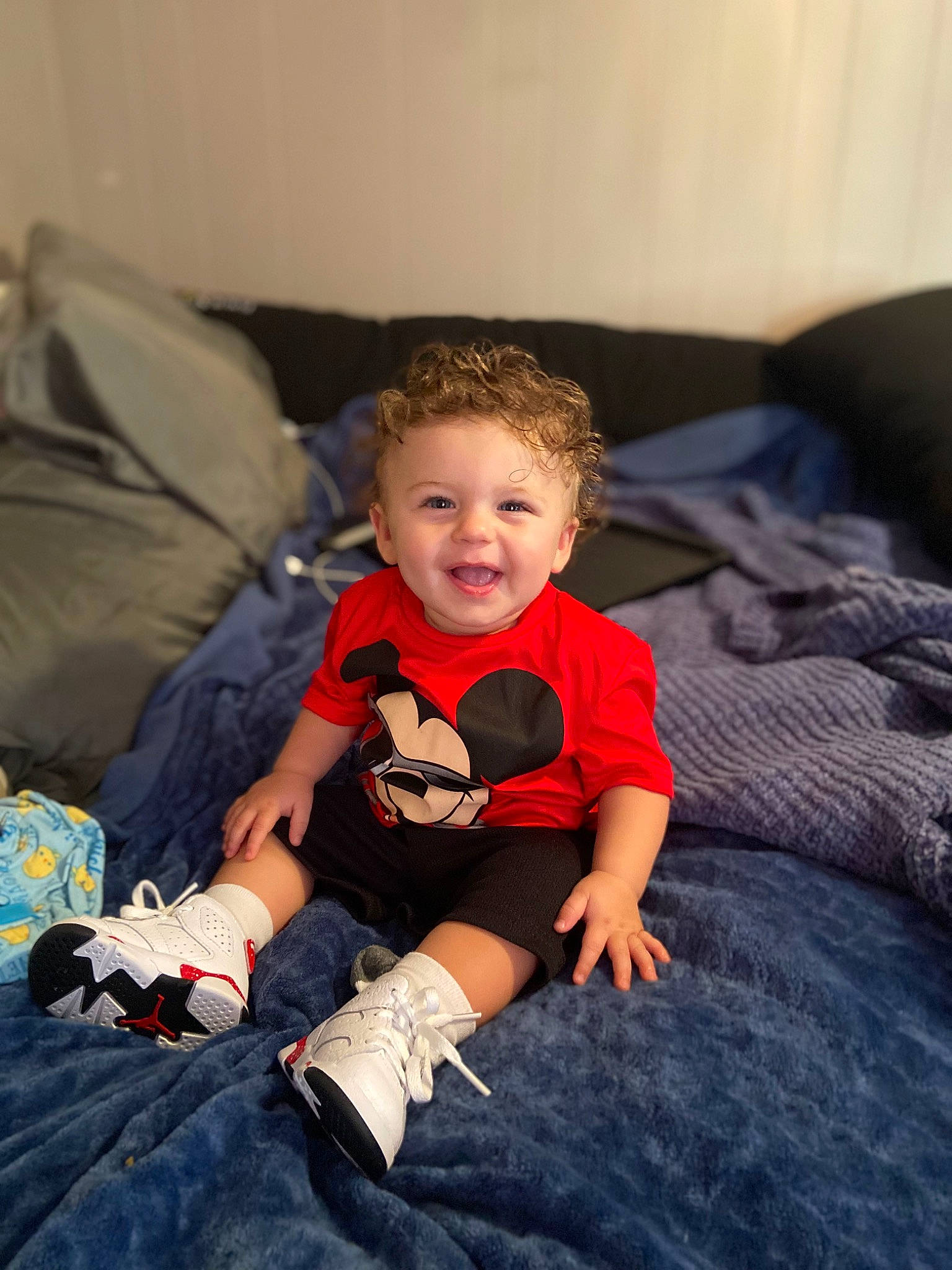 Logan is registered to the contest to win money with this photo: baby, baby_toddler_clothing, child, comfort, couch, electric_blue, eye, flash_photography, flooring, fun, happy, head, human_body, mammal, person, room, sitting, sleeve, smile, t_shirt