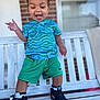 Navari joined the competition — help win amazing prizes! toddler, child, smiling, green_shorts, blue_shirt, sneakers, bench, outdoor, happy, playful, person, portrait, standing, expression, joyful, window, brick_wall, sock, hair, daylight
