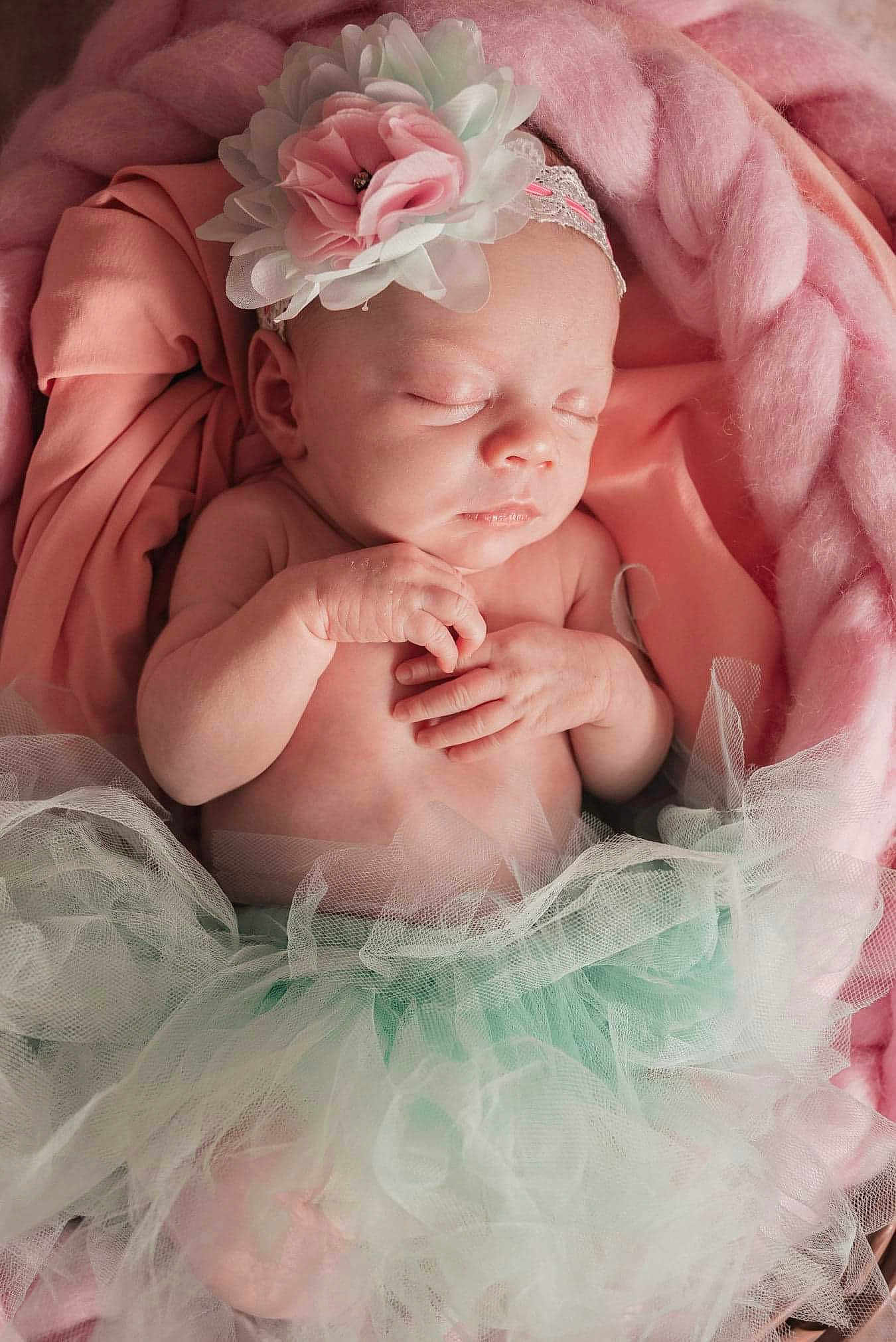 Léana participe au concours pour gagner de l'argent avec cette photo : arm, baby, baby_toddler_clothing, comfort, embellishment, face, finger, flash_photography, flower, hand, happy, headband, headgear, headpiece, iris, peach, petal, pink, skin, toddler