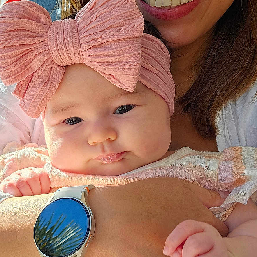 Jana Jane joined the competition — help win amazing prizes! arm, baby, child, closeup, clothing, drool, face, hand, happy, headband, indoor, person, pink_bow, portrait, skin, smile, sunlight, watch, window, woman