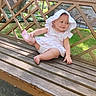 Clairissa is registered to the contest to win money with this photo: baby, child, infant, portrait, outdoor, garden, bench, wooden_bench, bonnet, dress, pink, white_clothing, sitting, smiling, barefoot, sunlight, trees, grass, backyard, lattice