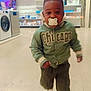 Ychane participe au concours pour gagner de l'argent avec cette photo : toddler, child, pacifier, green_jacket, walking, indoor, store, television, appliances, floor, white_shoes, pants, face, person, motion_blur, shopping, electronics, cute, young, hoodie