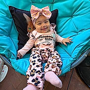 Sakinah a rejoint le concours — aidez-le/la à gagner de superbes lots ! baby, smile, headband, bow, pink_clothing, animal_print, chair, cushion, cat_pillow, happy, infant, indoor, portrait, cute, child, fashion, cozy, person, toddler, relaxing