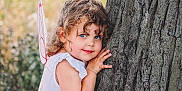 Emilia-rose is registered to the contest to win money with this photo: child, girl, curly_hair, blue_eyes, tree, fairy_wings, outdoor, nature, playing, smiling, cute, portrait, costume, whimsical, childhood, innocence, summer, daylight, happy, fun