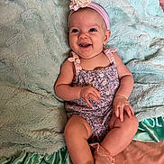 Maury Mckenzie joined the competition — help win amazing prizes! baby, child, smiling, headband, flower, blanket, sitting, romper, pink, blue, soft_texture, happy, cute, infant, portrait, indoors, sock, clothing, fabric, person