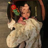 Mia joined the competition — help win amazing prizes! baby, blanket, car_seat, toy, headband, indoor, floor, caterpillar_toy, person, infant, pink_clothing, footwear, polka_dot, face, child, seated, carpet, cushion, curtain, cozy