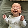 baby, infant, smile, onesie, bunny, bed, pillow, blanket, happy, lying_down, portrait, cute, newborn, chubby_cheeks, hands, eyes, skin, indoors, soft_light, clothing