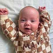 Jules a rejoint le concours — aidez-le/la à gagner de superbes lots ! baby, infant, smiling, lying_down, checkered_clothing, onesie, bed_sheet, arms_up, close_up, portrait, cute, newborn, eyes_open, head, skin, cheeks, indoor, soft_lighting, blanket, patterned_fabric