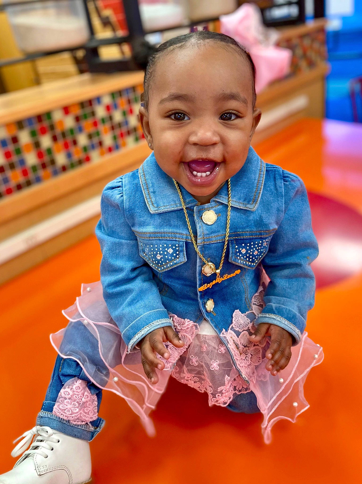 Loyalty is registered to the contest to win money with this photo: baby, baby_toddler_clothing, child, electric_blue, event, flooring, fun, happy, head, leisure, orange, person, play, room, sitting, skin, sleeve, smile, standing, t_shirt