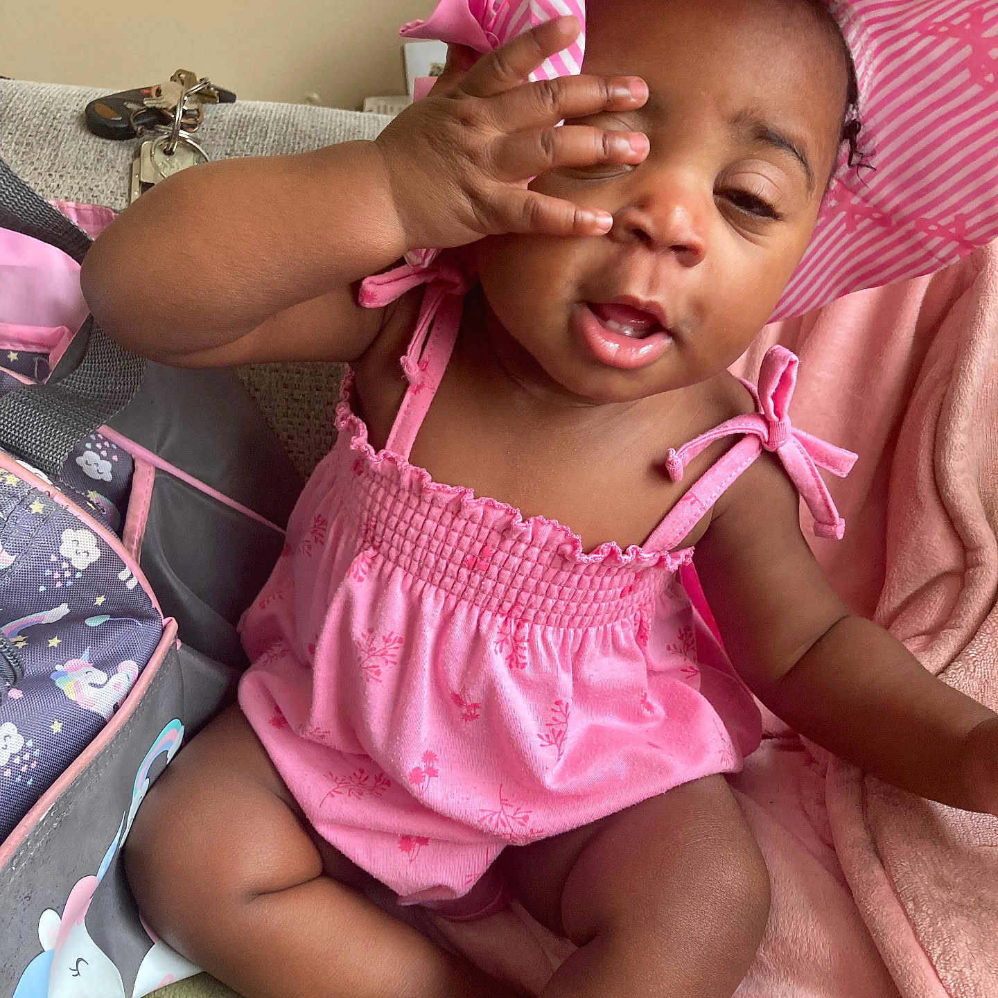 Kemyra is registered to the contest to win money with this photo: baby, infant, child, portrait, smiling, pink_outfit, sunhat, striped_hat, hand_on_face, sitting, indoor, blanket, stroller, bag, cozy, fashion, cute, happy, closeup, photography