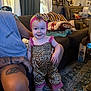 Ember joined the competition — help win amazing prizes! toddler, child, smiling, leopard_print, headband, pink, tattoos, adult, couch, pillows, rug, living_room, curtains, window, carpet, furniture, person, indoor, happy, portrait