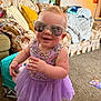 Ember is registered to the contest to win money with this photo: toddler, child, sunglasses, purple_tutu, smiling, indoor, carpet, couch, pillow, blanket, living_room, toy, reflection, happy, person, home, cute, playful, furniture, baby