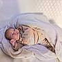 baby, blanket, infant, wrapped, cozy, soft_texture, clothing, face, head, lying_down, portrait, light_background, quilted, cute, newborn, peaceful, indoor, child, warm, resting