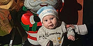 Kaylon participe au concours pour gagner de l'argent avec cette photo : baby, balloon, child, christmas, cute, decoration, festive, green_carpet, hand, hat, holiday, indoors, infant, onesie, person, santa_claus, shadow, standing, support, warm_lighting
