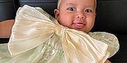 Yona joined the competition — help win amazing prizes! baby, infant, child, bow, headband, dress, smiling, tongue_out, black_leather, couch, floral_pattern, cute, playful, happy, portrait, close_up, person, indoors, fashion, accessory